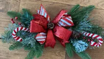 Winter theme swag with evergreen, candy cane and big red bow.