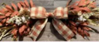 Fall decorative swag with ribbon and autumnal leaves.