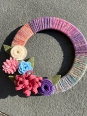 Colorful wreath with felt flowers and wrapped with yarn